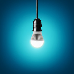 Glowing led bulb on blue background