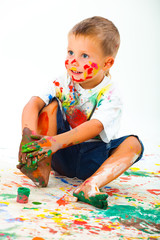 Smiling boy paints paints