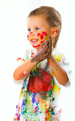 Smiling boy paints paints
