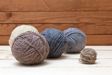 Balls of wool on wooden background