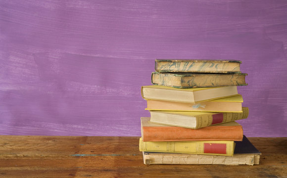 stack of books on purple background, free copy space