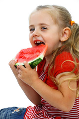 Little smiling girl eating watermelon