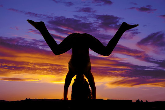 Silhouette hand stand legs knees bent