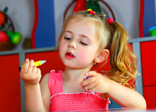A girl draws with crayons