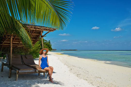 Woman in blue dress on a beach at Maldives