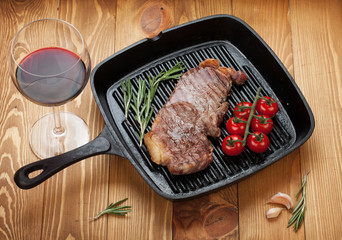 Sirloin steak with rosemary and cherry tomatoes on a frying pan