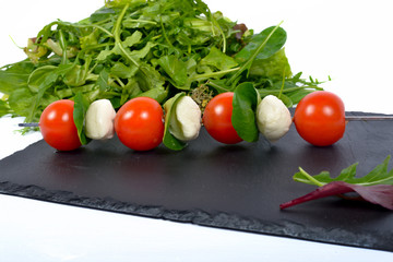 skewer tomatoes on a slate with salad