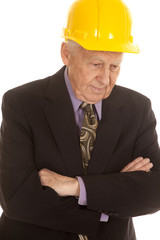 Elderly man suit hardhat arms folded look down