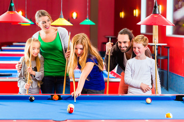 Familie spielt Poolbillard oder Billard