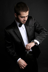 Handsome young man in suit on dark background