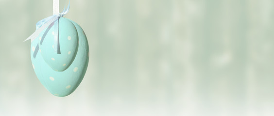 Fototapeta na wymiar Easter egg on ribbon, blue pastel background