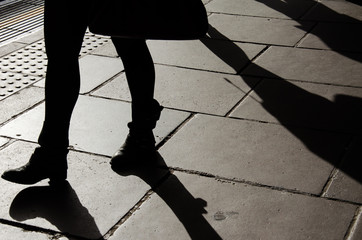 Silhouette of walking woman legs with boots - obrazy, fototapety, plakaty