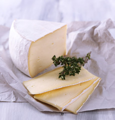Tasty Camembert cheese with thyme, on wooden table