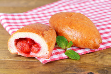 Fresh baked pasties with strawberries on plate on table