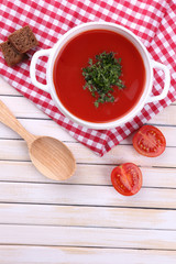 Tasty tomato soup on wooden table