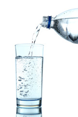 Pour water from bottle into  glass, on light blue background