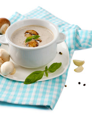 Mushroom soup in white pot, on napkin, isolated on white
