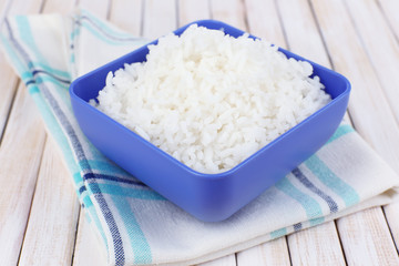 Cooked rice in bowl on wooden background