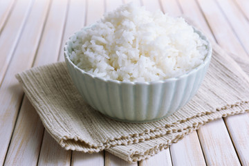 Cooked rice in bowl on wooden background