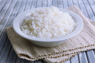 Cooked rice in bowl on wooden background