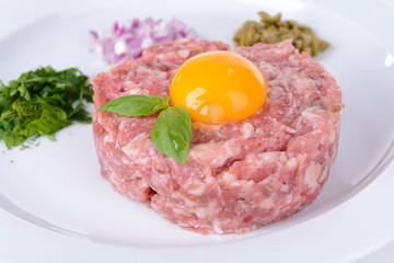 Delicious steak tartare with yolk on plate close-up