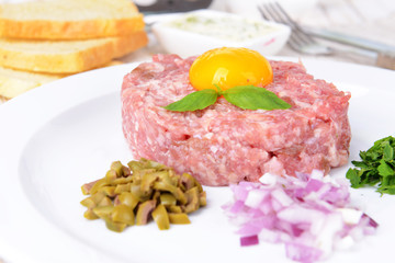 Delicious steak tartare with yolk on plate on table close-up