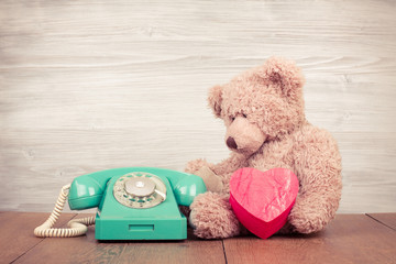 Teddy Bear with heart box near retro telephone - obrazy, fototapety, plakaty