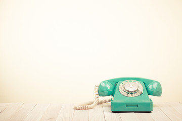 Retro mint green telephone on wooden table