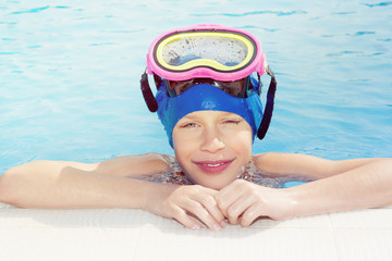 Beautiful child wearing a mask posing at swimming pool