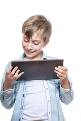 Cute stylish funny boy in a blue shirt playing at a tablet pc - 61463002