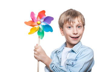 Beautiful cheerful blond boy holds a multicolored pinwheel