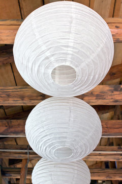 Three White Paper Lanterns (lampoons) On Wooden Ceiling