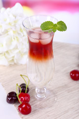Glass of cocktail on table on light background