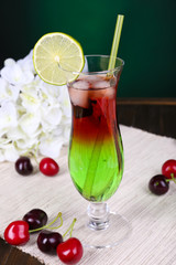 Glass of cocktail on table on dark green background