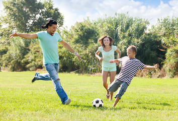  couple with son playing with soccer ball
