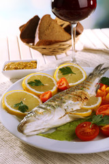 Delicious grilled fish on plate on table close-up