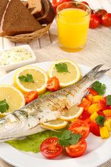 Delicious grilled fish on plate on table close-up
