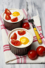 Baked eggs on wooden table close up