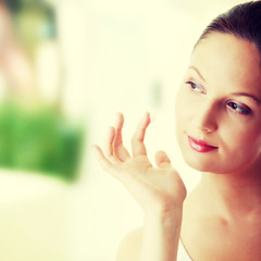 Woman applying moisturizer cream on face