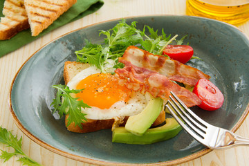 Scrambled eggs with bacon and avocado.