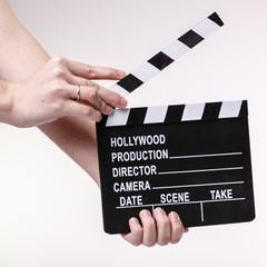 Obraz premium Movie flapper in woman´s hands on white background