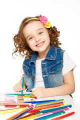 Cheerful little girl with felt-tip pen drawing in kindergarten