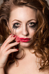 Attractive girl with smeared make-up and polished nails