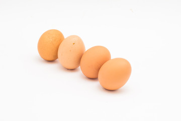 Brown   eggs lined up diagonally on white background