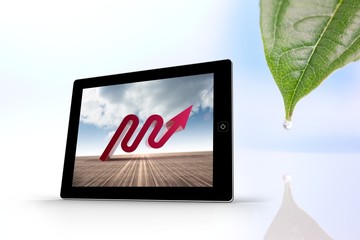 Composite image of red arrow on tablet screen