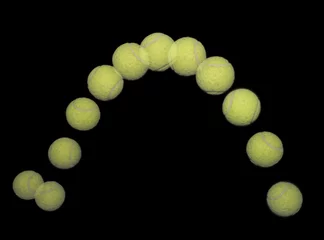 Cercles muraux Sports de balle Balle de tennis rebondissante sur le noir.