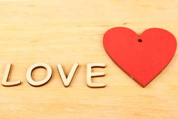 Heart and the text "love" on wooden background