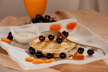 Stack of pancakes with fruits, nuts and honey.