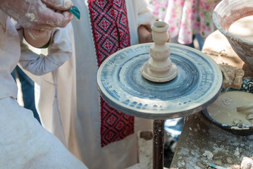 Potter guiding pottery to boy