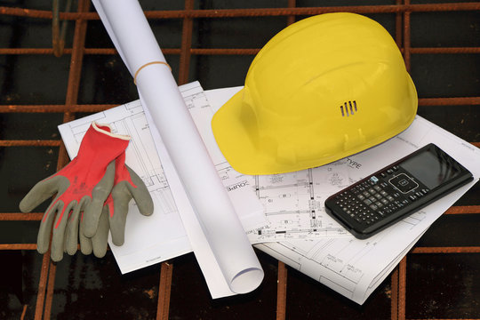 casque de chantier, plans, calculatrice et gants